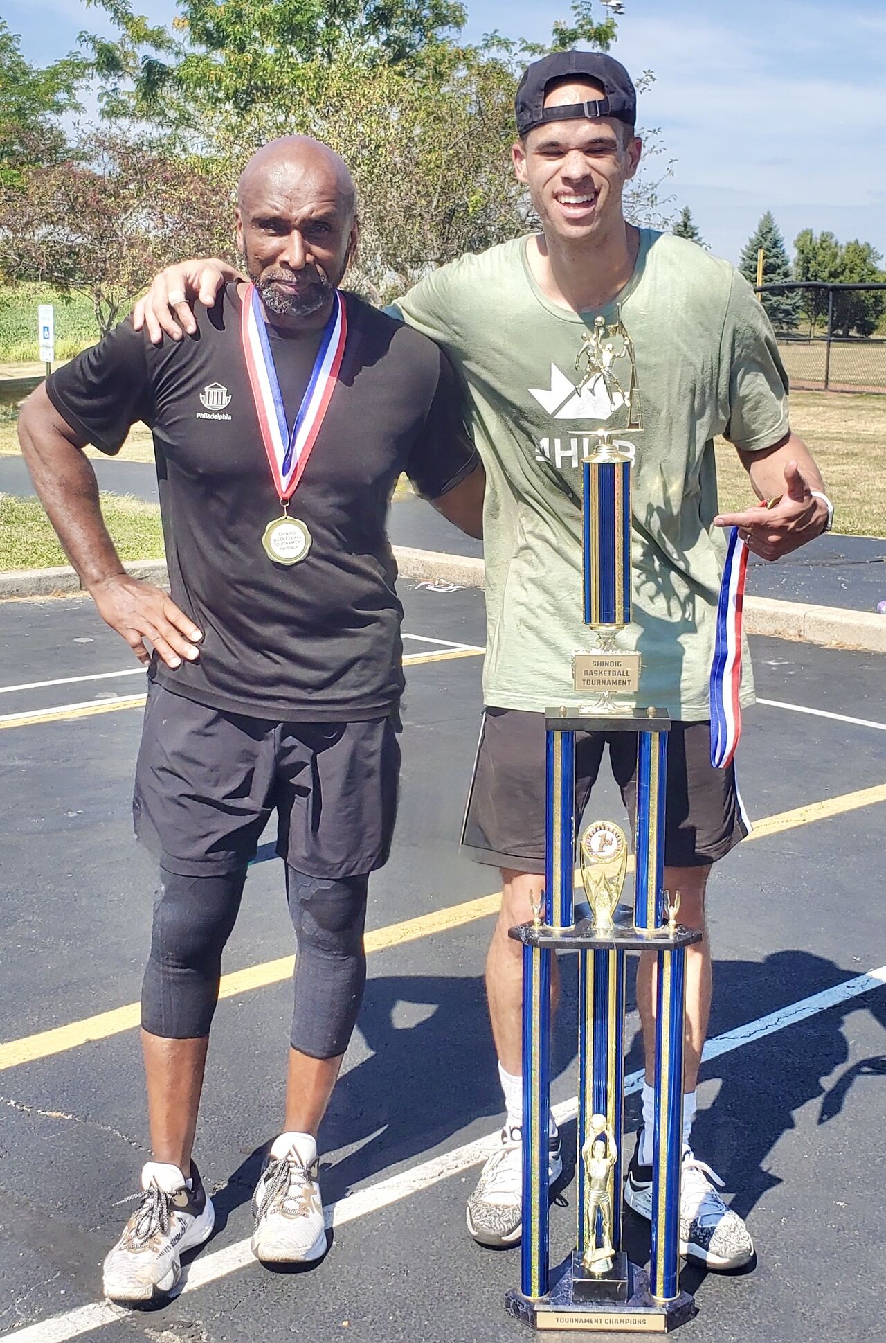 Eric Roberson and his father with a basketball trophy after winning a local tournament.