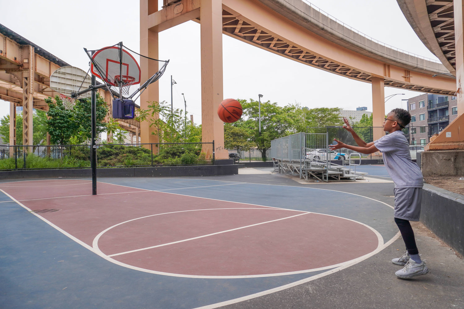 Teenage boy receiving a pass from the HOOPTEQ shooting machine during basketball training.